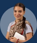 Sixth form student smiling and holding a notebook on a grey background.